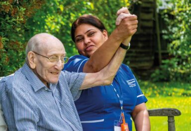 Man and care assistant raise their hands 1